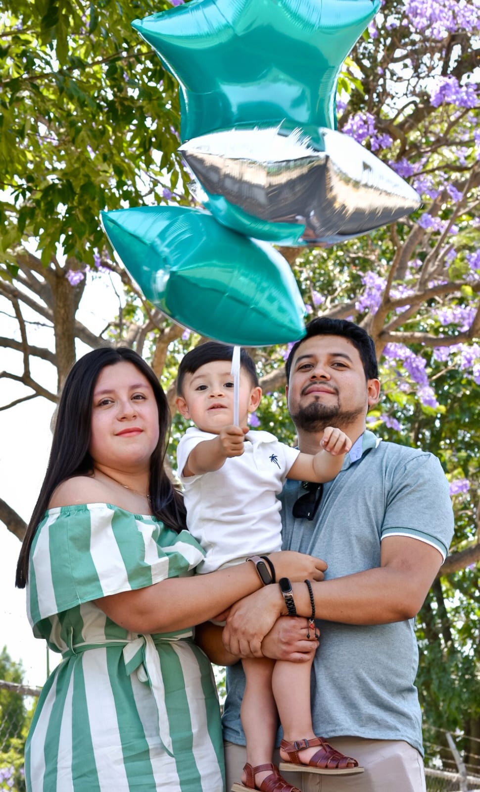 Familia con globos bajo la jacaranda